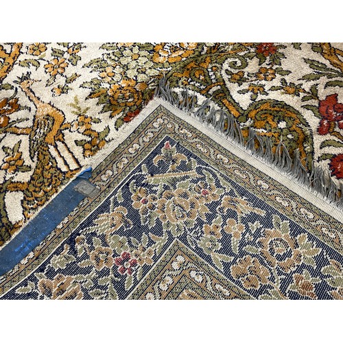 57 - A Persian silk and wool mix rug / carpet, the field knotted with Tree of Life and exotic birds, encl... 