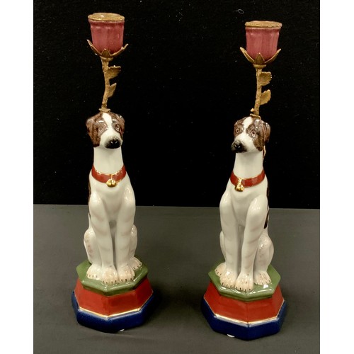 59 - A pair of painted dog porcelain candlesticks, on octagonal plinth, printed mark to base, 34cm high (... 