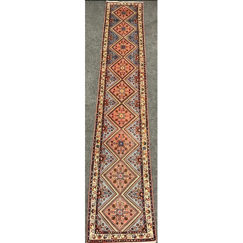 62 - A North West Persian Rudbar Runner carpet, hand-knotted with a row of nine diamond-shaped medallions... 