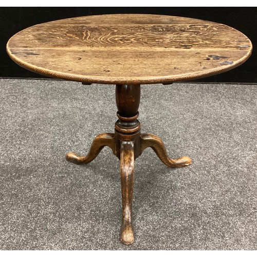 65 - A George III oak table, circular plank top, turned column, tripod feet, 56cm high, 68cm diameter, (l... 