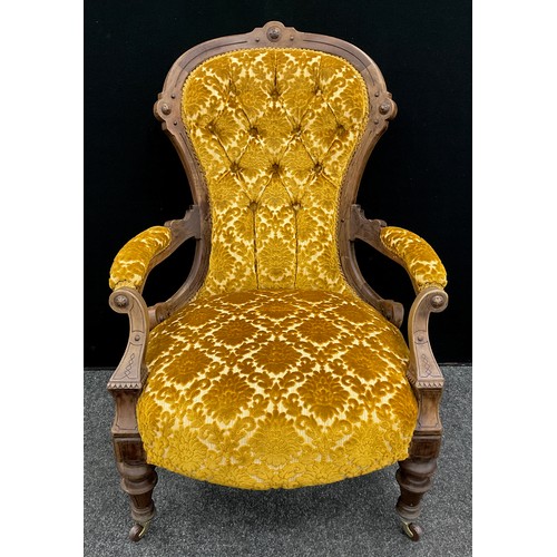 73 - A Victorian walnut spoon-back armchair, deep-button upholstered back, carved scroll arms, turned leg... 