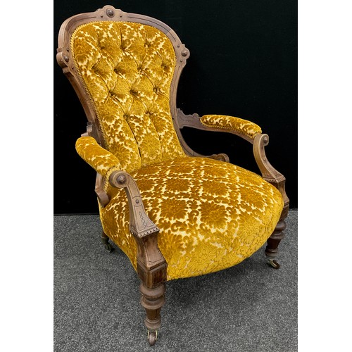 73 - A Victorian walnut spoon-back armchair, deep-button upholstered back, carved scroll arms, turned leg... 