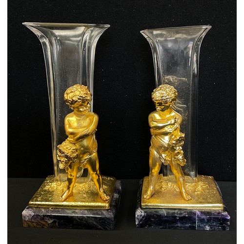 114 - A pair of gilt metal and glass figural spill vases, as Bacchanalian figures holding Masks, stood bef... 