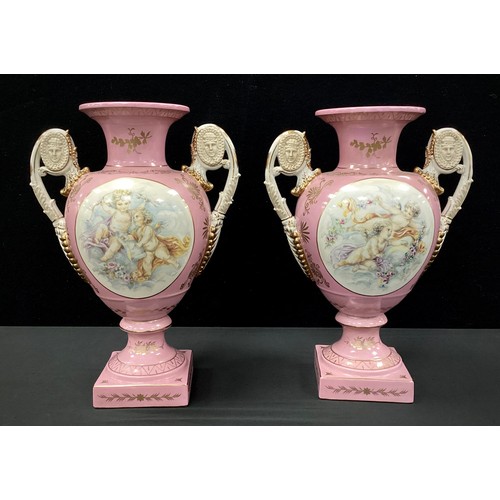 212 - A pair of Sevres style pink cherub vases, twin handled, decorated with printed cherubs on pink groun... 