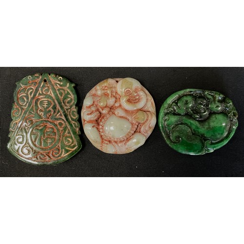 261 - Three Chinese and Japanese tablet pendants, in multi tone green jade colours, as Hotei etc (3)