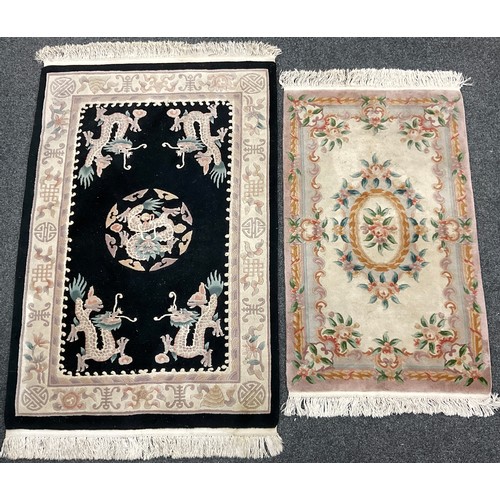 189A - A Chinese wool pile carpet, knotted with dragons and stylised flowers in cream and pink on a black g... 