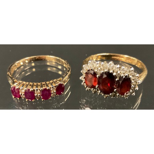 363 - A ruby and diamond ring, linear set with four oval red rubies divided by pairs of diamond accents, 9... 