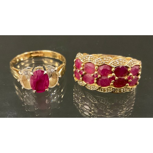 366 - A ruby and diamond cluster ring, with two rows of five oval cut pinky red rubies, between diamond ac... 