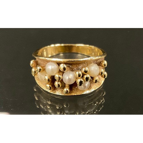 371 - Style of Karlheinz Sauer (Bn 1943 Germany) a 9ct gold seed pearl ring, with tapering stylised crest.... 