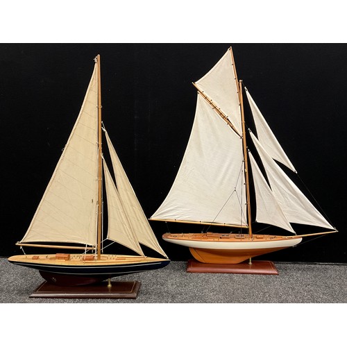 144 - A model five-sail wooden yacht, 95cm high x 82cm long;  another, smaller yacht, (2).