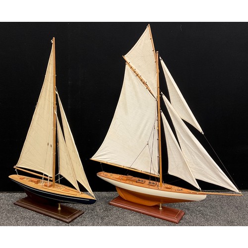 144 - A model five-sail wooden yacht, 95cm high x 82cm long;  another, smaller yacht, (2).