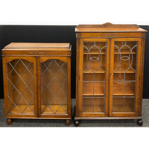 146 - An early 20th century oak bookcase cabinet, quarter galleried top, carved decoration to frieze, glaz... 