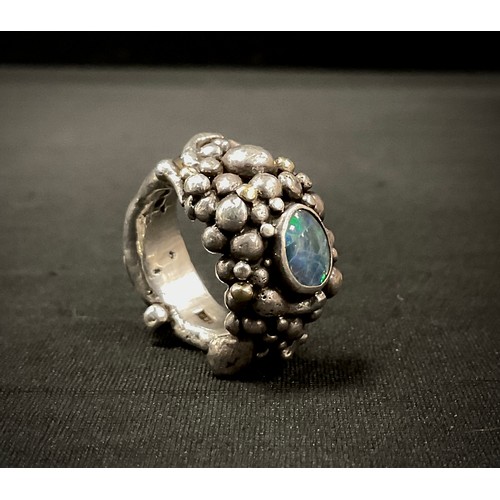 256 - A modernist Michael Allen Bolton (Cornish) silver opal set ring, cast as a multi section rocky clust... 