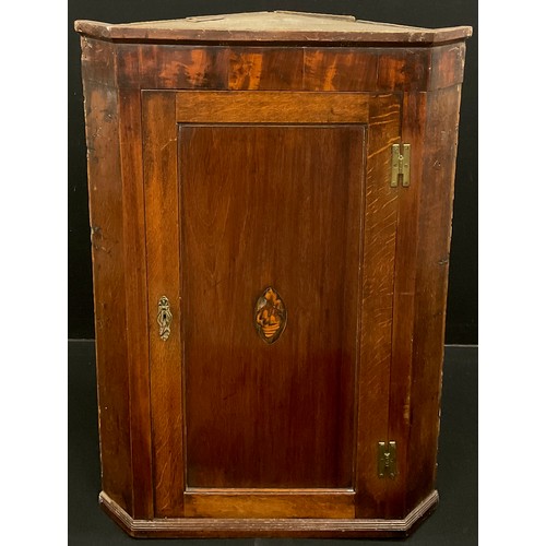 170A - A George III oak corner cupboard, inlaid shell patera to the panelled door, enclosing three tiers of... 