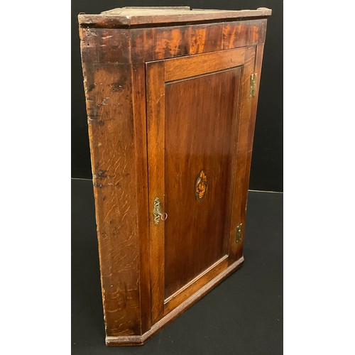 170A - A George III oak corner cupboard, inlaid shell patera to the panelled door, enclosing three tiers of... 