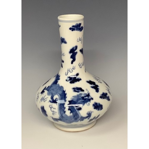 74 - A Chinese export ware compressed ovoid bottle vase, decorated in underglaze blue with dragons and cl... 