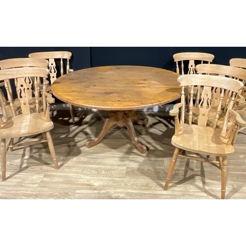 100 - A farmhouse pine circular dining table, 72cm high, 151.5cm diameter; a set of seven beech carver din... 