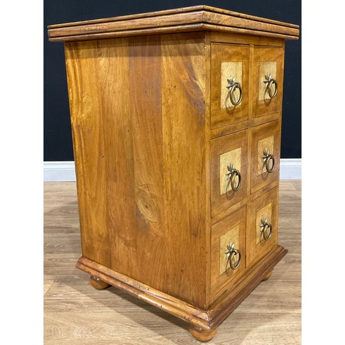 109 - An oak chest of drawers, of small proportions, the overhanging moulded cornice above three pairs of ... 