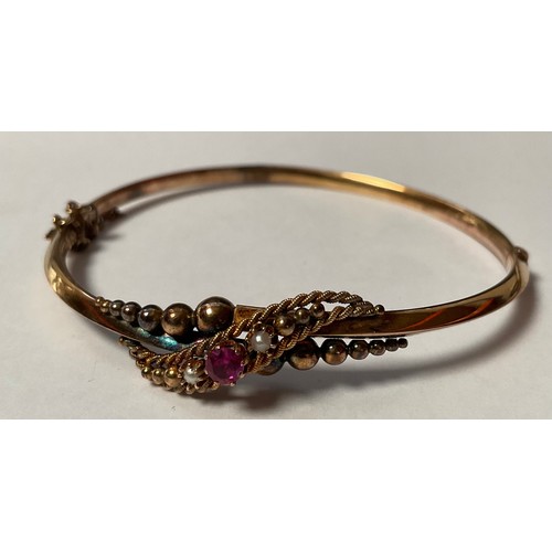 465 - An Edwardian 9ct gold hinged bangle, set with seed pearl and ruby stones, marked 9ct, safety clasp, ... 