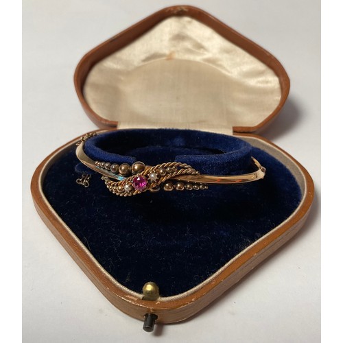 465 - An Edwardian 9ct gold hinged bangle, set with seed pearl and ruby stones, marked 9ct, safety clasp, ... 