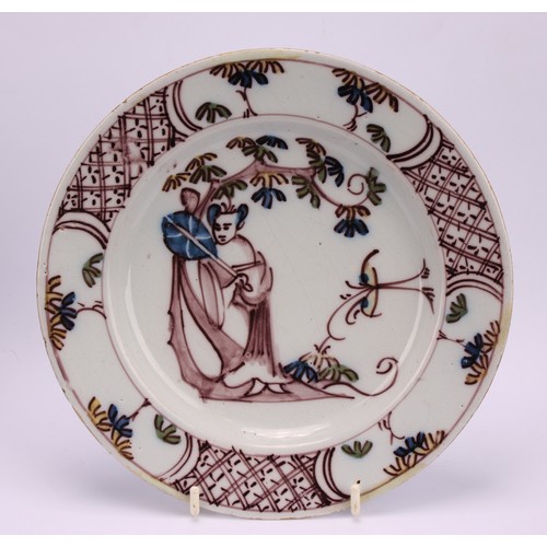 53 - An 18th century Delft circular plate, painted in the chinoiserie taste with a figure in a Chinese ga... 
