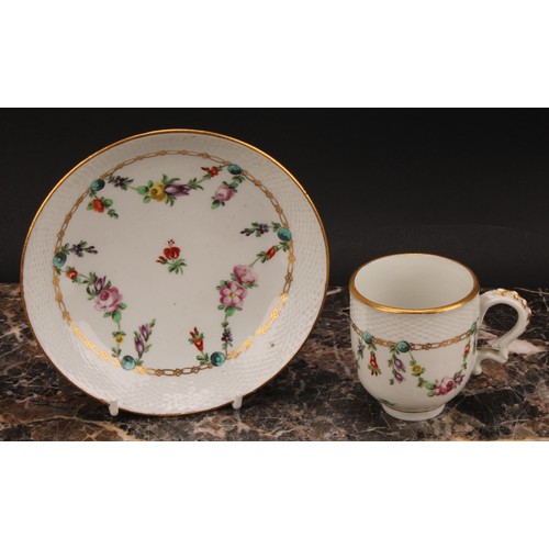 68 - A Bristol coffee cup and saucer, basket weave moulded border, enamelled with polychrome swags suspen... 