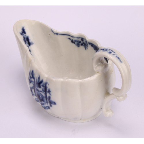 77 - A Cookworthy Bristol butter boat, of fluted form, painted in underglaze blue with flowers, 11cm long... 