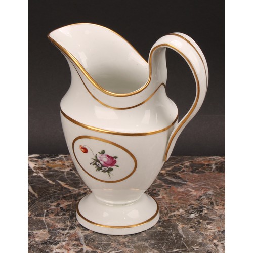 94 - A Thomas Wolfe Factory Z helmet shaped cream jug, painted with flowers within an oval gilt cartouche... 