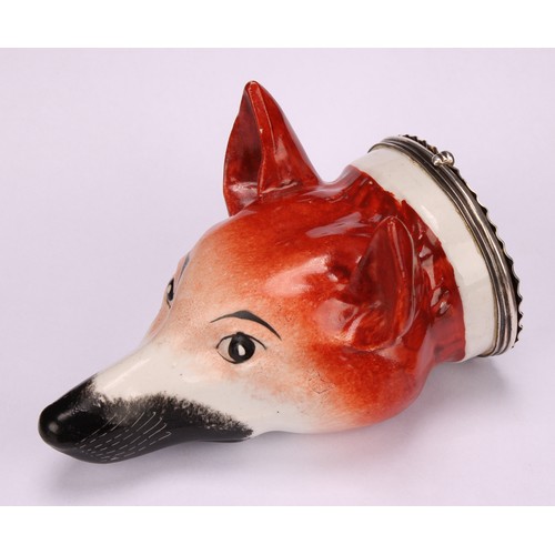 92 - A Staffordshire pottery novelty stirrup cup, modelled as a fox mask, naturalistically painted, silve... 