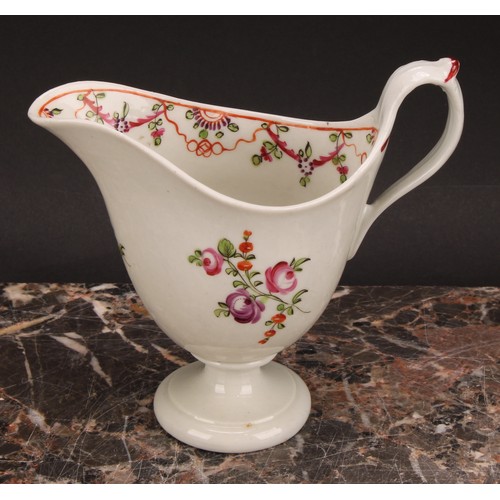 105 - A Newhall helmet shaped cream jug, painted with scattered flowers, the interior with stylised floral... 