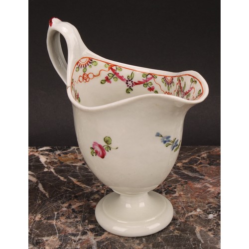 105 - A Newhall helmet shaped cream jug, painted with scattered flowers, the interior with stylised floral... 