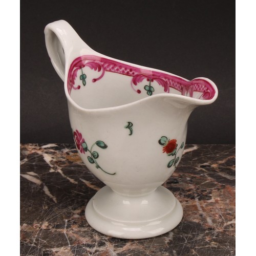 105 - A Newhall helmet shaped cream jug, painted with scattered flowers, the interior with stylised floral... 