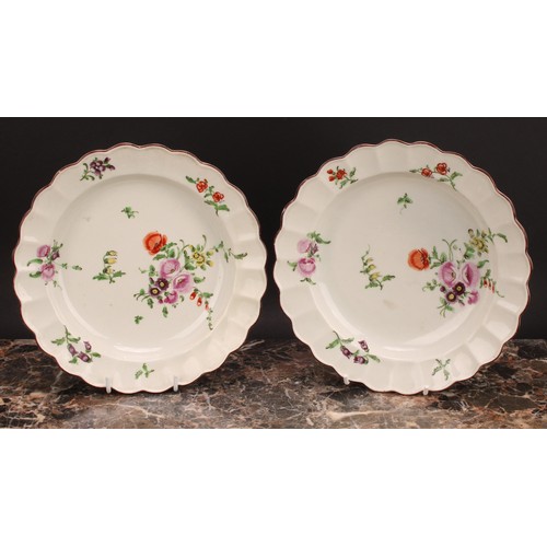 120 - A pair of Worcester shaped circular plates, painted in polychrome with scattered flowers and sprigs,... 