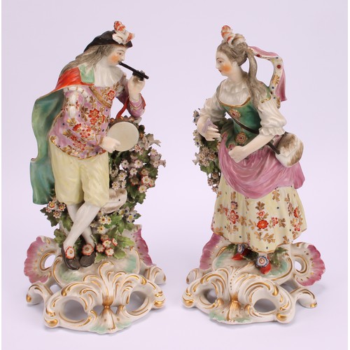 175 - A Derby pair of patch mark figures, of Musicians, she stands playing the triangle, wearing feathers ... 