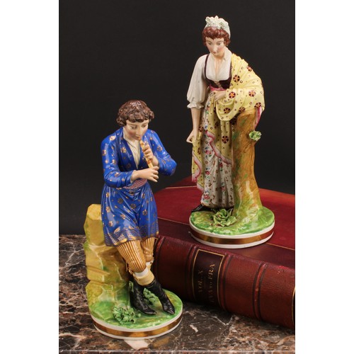 180 - A pair of Bloor Derby figures, of a musician and his companion, he seated on rocky outcrop playing h... 