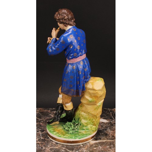 180 - A pair of Bloor Derby figures, of a musician and his companion, he seated on rocky outcrop playing h... 