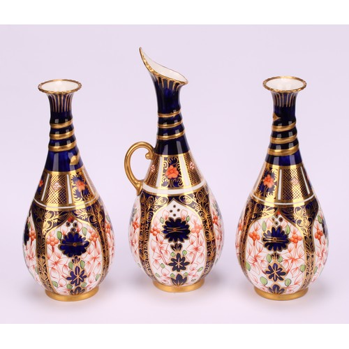 196 - A pair of Royal Crown Derby 1128 Imari pattern ovoid bottle vases, the slender necks moulded with sp... 