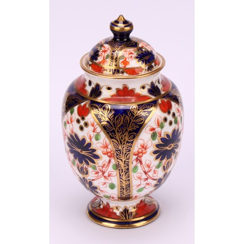 197 - A pair of Royal Crown Derby 1128 Imari pattern ovoid pedestal vases and covers, circular bases, 13cm... 