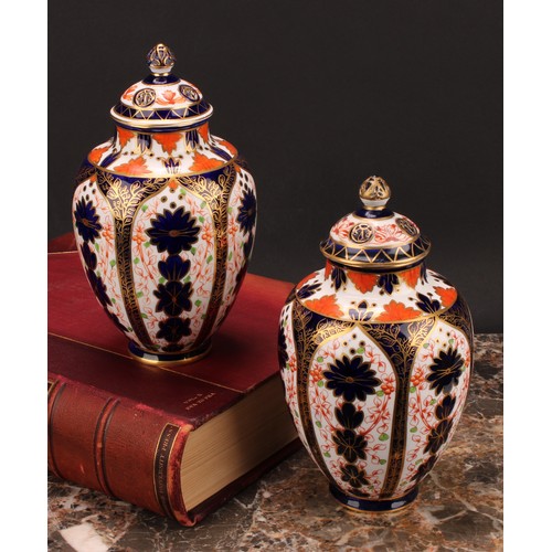 247 - An associated pair of Royal Crown Derby ovoid vases, pierced domed covers and finials, 21cm high, pr... 