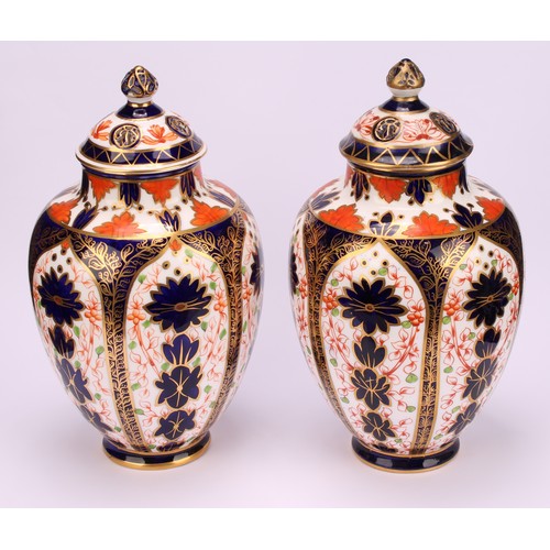 247 - An associated pair of Royal Crown Derby ovoid vases, pierced domed covers and finials, 21cm high, pr... 