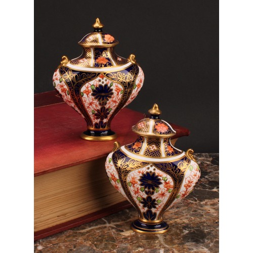 239 - An associated pair of Royal Crown Derby 1128 Imari pattern flattened ovoid pedestal vases, oval dome... 