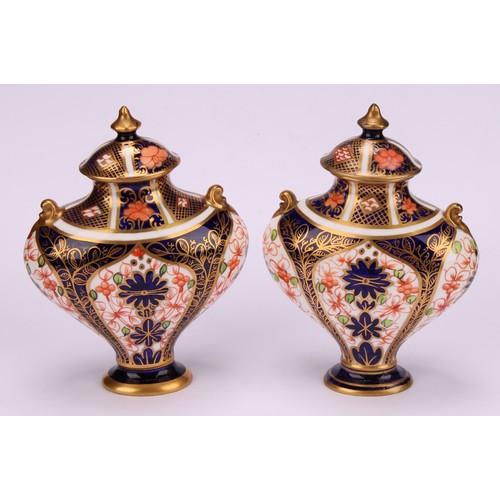 239 - An associated pair of Royal Crown Derby 1128 Imari pattern flattened ovoid pedestal vases, oval dome... 