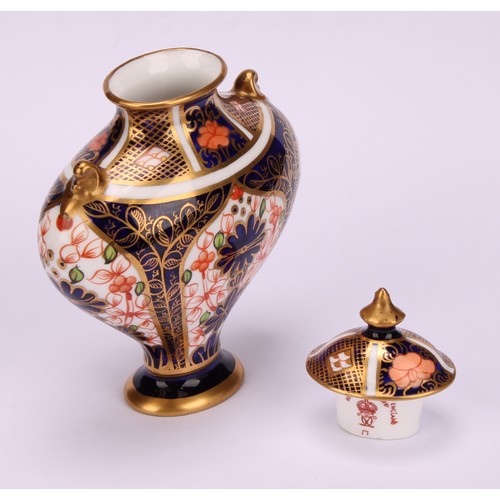 239 - An associated pair of Royal Crown Derby 1128 Imari pattern flattened ovoid pedestal vases, oval dome... 