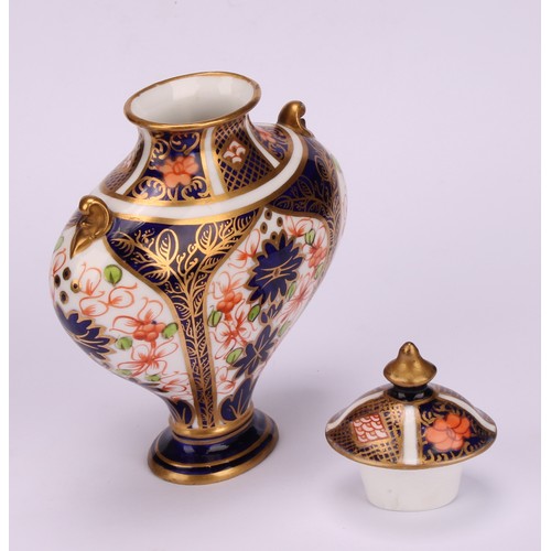 239 - An associated pair of Royal Crown Derby 1128 Imari pattern flattened ovoid pedestal vases, oval dome... 