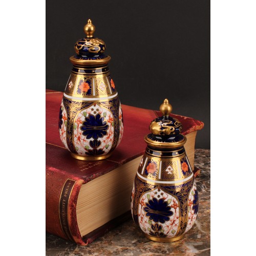 198 - A pair of Royal Crown Derby 1128 Imari pattern ovoid vases, shaped domed covers moulded with sinuous... 