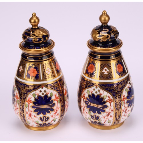 198 - A pair of Royal Crown Derby 1128 Imari pattern ovoid vases, shaped domed covers moulded with sinuous... 