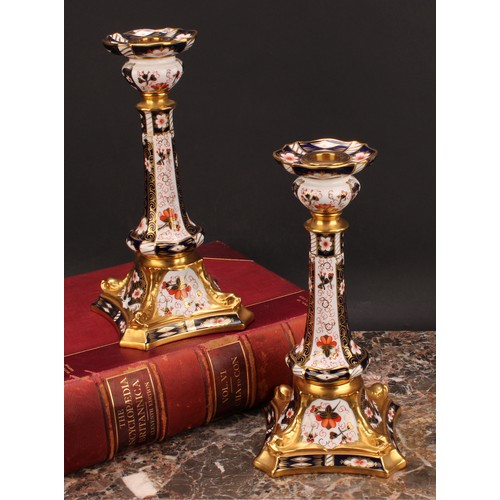 200 - A pair of Royal Crown Derby Imari 2451 pattern Kedleston candlesticks, the square bases with dolphin... 