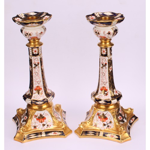 200 - A pair of Royal Crown Derby Imari 2451 pattern Kedleston candlesticks, the square bases with dolphin... 