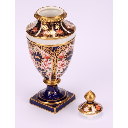 194 - A near pair of Royal Crown Derby 1128 Imari pattern ovoid pedestal vases, domed covers, gilt finials... 