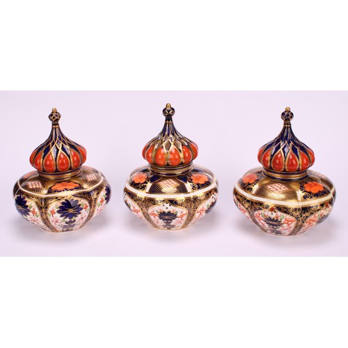 241 - An associated pair of Royal Crown Derby 1128 Imari pattern lobed ovoid vases and covers, of compress... 